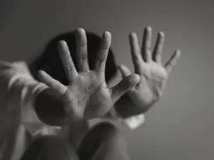 Person shielding themselves with hands