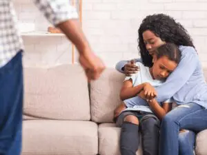 Mother comforting child during domestic conflict