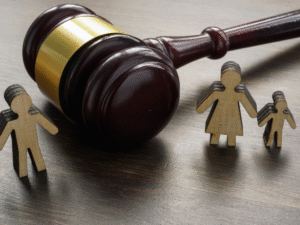 Close-up of a judge’s gavel beside wooden cutouts symbolizing parents and children, representing San Diego County custody mediation and Family Court Services proceedings. The image conveys the confidential and court-ordered mediation process, mediator influence on custody reports, and legal preparation strategies guided by Mattis Law, A.P.C. family attorneys in La Jolla.