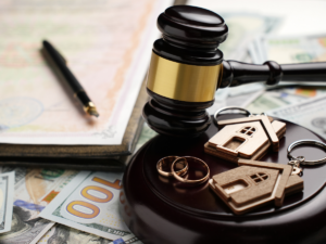 A composite image featuring legal-themed visuals, including a judge’s gavel, financial documents, and property-related icons, partially overlaid with blurred interface elements. Despite the layered design, the underlying imagery reflects the intersection of family law, financial assets, and property considerations—symbolizing the complex factors involved in high-asset divorce and child custody decisions, such as wealth, real estate, and financial planning.