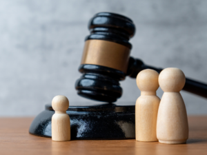 Judge's gavel beside wooden figures representing parents and a child, illustrating the legal process that follows when child custody mediation fails in San Diego family court.