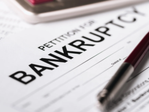Bankruptcy petition and pen representing the financial and legal issues that can arise when a spouse files for bankruptcy during or after a divorce.